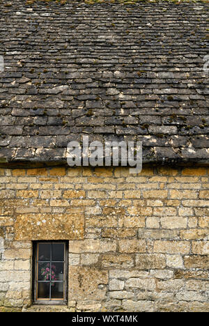 Gelbe Cotswold Kalkstein Mauer Haus mit Naturschiefer Dach und Fenster mit Blumen in Snowshill Gloucestershire England Stockfoto