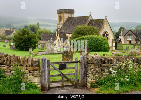 St Barnabas anglikanische Kirche mit Friedhof und Mauer Tor in feuchten regnerischen Wetter in Snowshill Cotswold England Stockfoto