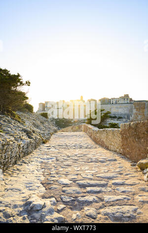 Einen atemberaubenden Sonnenuntergang, ein Weg, der mit dem schönen Dorf von Bonifacio von alten Mauern umgeben leuchtet auf. Südlich von Korsika, Frankreich. Stockfoto