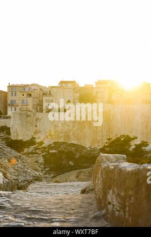 Einen atemberaubenden Sonnenuntergang, ein Weg, der mit dem schönen Dorf von Bonifacio von alten Mauern umgeben leuchtet auf. Südlich von Korsika, Frankreich. Stockfoto