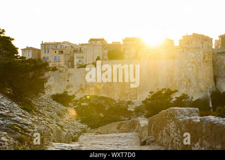 Einen atemberaubenden Sonnenuntergang, ein Weg, der mit dem schönen Dorf von Bonifacio von alten Mauern umgeben leuchtet auf. Südlich von Korsika, Frankreich. Stockfoto