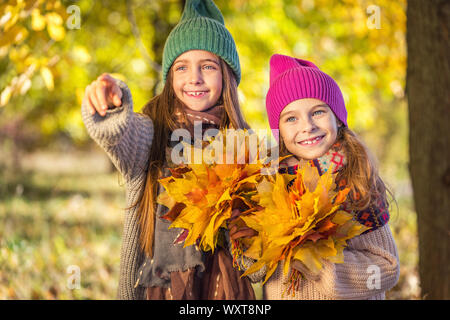 Zwei süße Lächeln 8 Jahre alten Mädchen zusammen zu Fuß in einem Park an einem sonnigen Herbsttag. Stockfoto