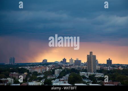 Eine sich nähernde Regenwolke erzeugt eine dramatische und atmosphärische Szene über einer städtischen Skyline, die das wechselnde Wetter symbolisiert. Stockfoto