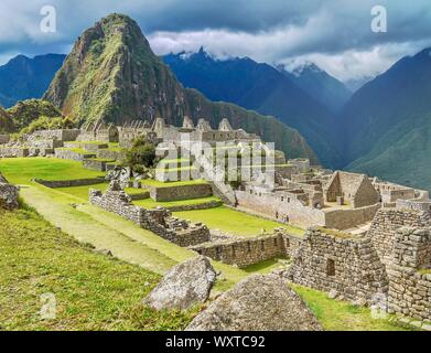 Eine Nahaufnahme der Ruinen und lebhaften grünen Terrassen an der Basis des Huayna Picchu Mountain im schönen Machu Picchu, Peru. Stockfoto