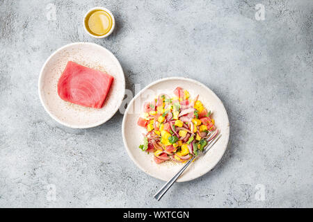 Gourmet mango Salat Thunfisch Tartar mit Koriander und violette Zwiebel auf weiße Platte Stockfoto