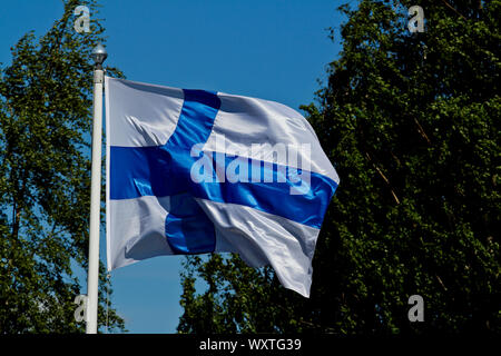 Finlands, blau-weiße Fahne schwenkten im Wind an einem sonnigen Tag Stockfoto