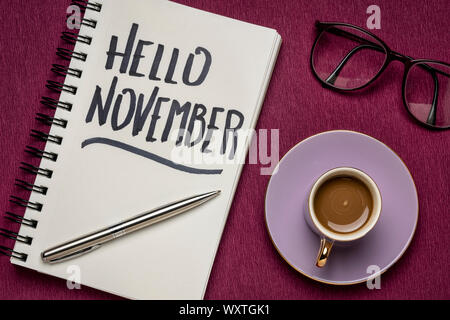 Hallo November - Handschrift in einem Notebook mit einer Tasse Kaffee, Arbeitsbereich business Flach Stockfoto