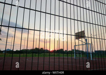 Im freien Mini Fußball- und Basketballplatz mit Ball Gate und Korb mit hoher Schutzzaun umgeben. Stockfoto