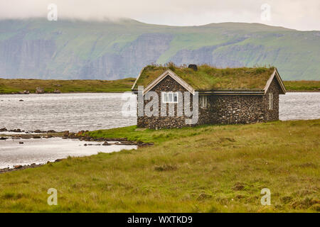 Traditionelle Färöer Steinhaus mit Rasen Dach in Kalsoy Insel Stockfoto