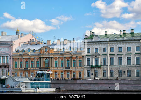 St. Petersburg, Russland, April 2019: Fassade eines alten Gebäudes an der Promenade des Anglais, Fluss Newa und Freude touristische Motor Schiffe Stockfoto