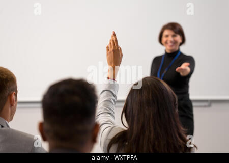 Business, Bildung und Personen Konzept - lächelnd Geschäftsfrau oder Lehrer beantwortet Fragen bei der Konferenz Präsentation oder Vorlesung Stockfoto