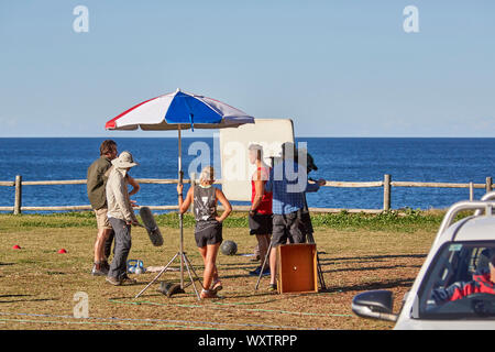 Schauspieler und Crew, darunter ein Sound Ausleger und Bediener der Kamera Filmen einen Outdoor Szene von Haus & entfernt Fernsehprogramm im Palm Beach, Australien Stockfoto