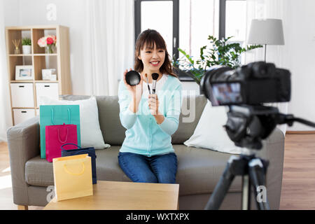 Blogging, Technologie, videoblog und Personen Konzept - Glücklich lächelnde Asiatische Schönheit Blogger mit der Videokamera Video Blog über Make-up und Kosmetik ein Stockfoto