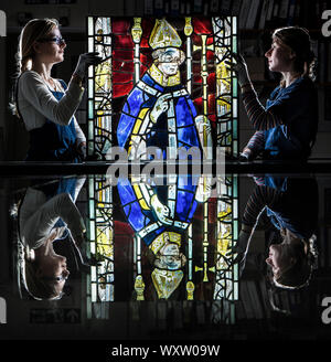 Restauratoren Monika Adamczak (links) und Lydia Walter von York Glaser Trust, Großbritannien die älteste und größte Spezialist Glasmalerei Erhaltung studio, halten Sie einen 600 Jahre alten Panel von einem der York Minster's Windows. Stockfoto