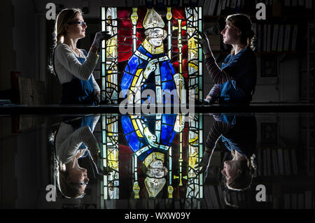 Restauratoren Monika Adamczak (links) und Lydia Walter von York Glaser Trust, Großbritannien die älteste und größte Spezialist Glasmalerei Erhaltung studio, halten Sie einen 600 Jahre alten Panel von einem der York Minster's Windows. Stockfoto