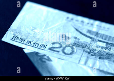 Zwei Rechnungen von 20 Hongkong Dollar auf einem dunklen Hintergrund. Blaue Farbe getönt Stockfoto