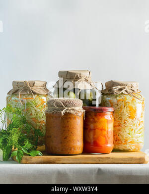 Fermentierte oder canning verschiedene Gemüse zucchini Möhren sauerkraut Gurken in Gläsern auf einem Tisch. Verarbeitung der Herbst Ernte. Natürlichen rustikalen Stil Stockfoto