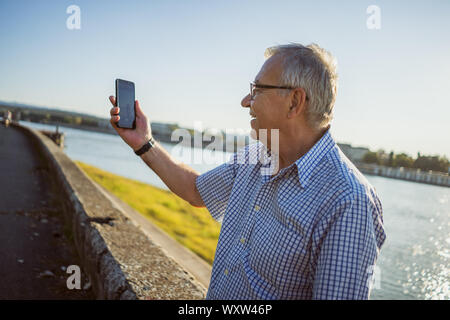 Outdoor Portrait von älteren Mann hat, der selfie. Stockfoto