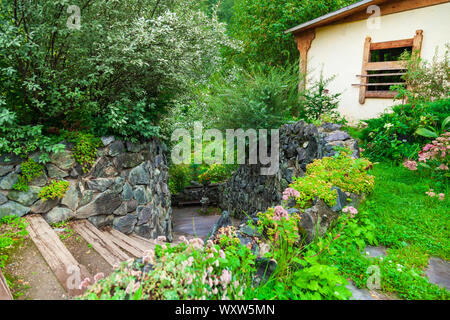 Ein kleines süsses Haus außerhalb der Stadt für den Sommer leben und Erholung im Freien, um Die herum gibt es einen schönen blühenden Garten mit grünen Blätter hängen Stockfoto