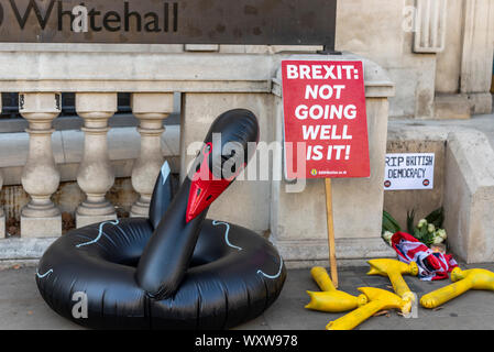 Protest außerhalb des Cabinet Office in Whitehall, Westminster, London, Großbritannien. Brexit fragen. Black Swan aufblasbaren Ring. Plakate. RIP-britischen Demokratie Stockfoto