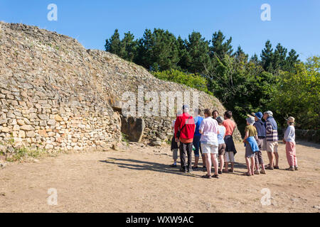 Cairn der Insel Gavrinis in Larmor Baden im Golf von Morbihan (Bretagne, Frankreich). Gruppe von Touristen vor der Cairn für Stockfoto