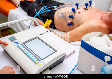Kardiologe mit EKG-Geräte, Elektrokardiogramm Test des Patienten, der mit Vakuum Sensoren an der Maschine befestigt ist. Stockfoto