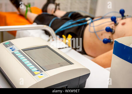 Kardiologe mit EKG-Geräte, Elektrokardiogramm Test des Patienten, der mit Vakuum Sensoren an der Maschine befestigt ist. Stockfoto