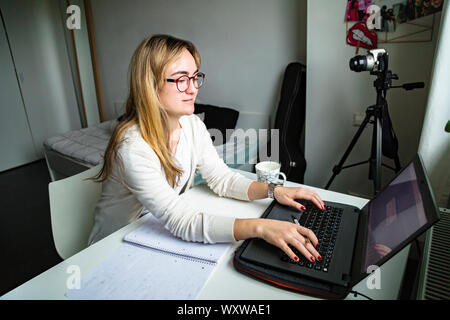 Frau, die zu Hause mit einem Laptop schreibt und arbeitet Stockfoto