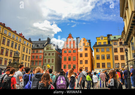 Alten bunten Häuser rund um den Stortorget (Grand Square) in Gamla Stan mittelalterliche Stadtzentrum von Stockholm, mit einer großen Gruppe von Touristen Stockfoto