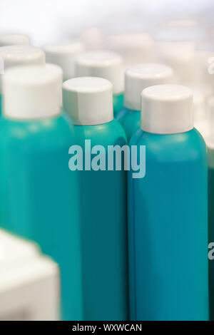 Zeile mit blauen leere Flaschen mit kosmetischen Produkten im Shop. Cremes und andere Produkte für die Hautpflege von Gesicht und Körper Stockfoto
