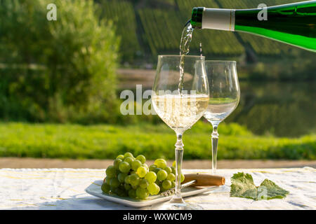 Kellner gießen Deutsche Qualität Weißwein Riesling, in Mosel Wein regio aus weißen Trauben an den Hängen der Hügel in Mosel River Valley in wachsenden produziert Stockfoto