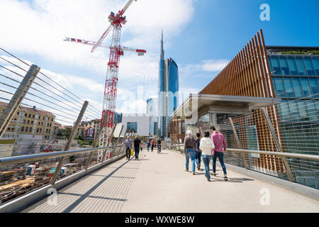 Mailand, Italien: die Fußgängerbrücke in der Nähe der Porta Nuova Varesine Bezirk mit der Baustelle Krane für die neue Wolkenkratzer als vertikale Nest Stockfoto