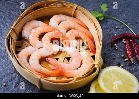 Frische Garnelen auf Bambus Dampfer mit Gewürzen lemon Chili auf der dunklen Platte/gekochte geschälte Garnelen Garnelen im Seafood Restaurant zubereitet Stockfoto