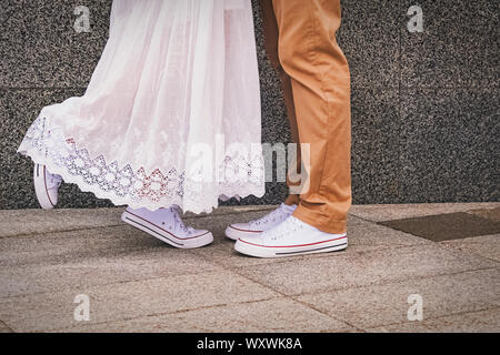 Nahaufnahme des Mannes und der Frau die Füße im gleichen Turnschuhe, vor jedem anderen ständigen. Romantischen Spaziergang oder dating in der Stadt. Stockfoto