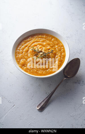 Pürierter Kürbis Suppe mit Samen und Thymian. Warmes Essen Konzept, nähren. Konkreten Hintergrund, Ansicht von oben. Stockfoto