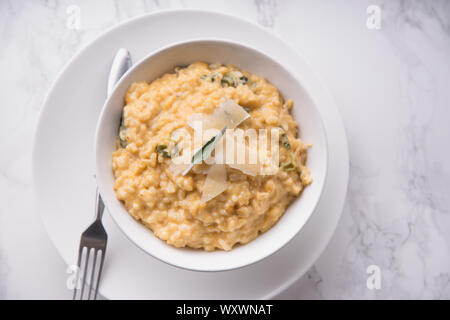 Kürbis risotto mit Parmesan und Salbei. Weißer Marmor Hintergrund Stockfoto
