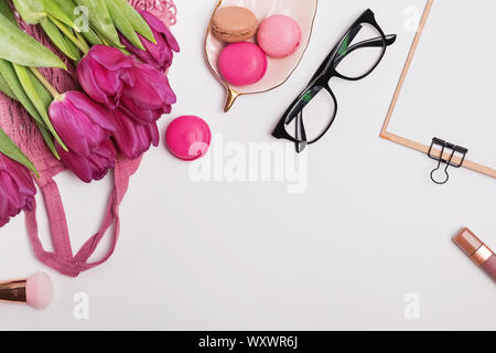 Lila Tulpen, Macarons und stilvoll weibliche Zubehör auf dem weißen Tabelle, Ansicht von oben Stockfoto