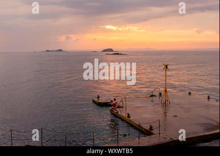 Menschen am Pier, den Sonnenuntergang genießen. North Berwick Sommer täglich Szenen und Landschaften. Stockfoto