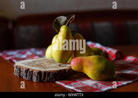 Gelb reife Birnen auf einem Holztisch. Zusammensetzung der Früchte. Herbst Ernte von Früchten. Stockfoto