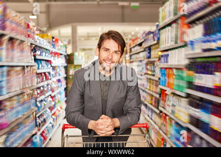 Erfüllt der Mensch als Kunde im Supermarkt oder Discounter zwischen Regalen Stockfoto