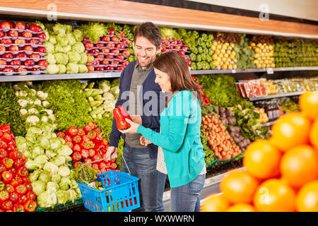Junges Paar im Supermarkt in der Gemüseabteilung beim Kauf Paprika Stockfoto
