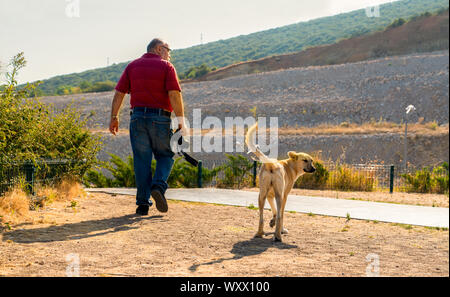 Sogut, bilecik/Türkei - 8. September 2019: Zurück (hinten) Ansicht eines alten Fotografen Mann und einer Straße Hund wandern togethercoordinately Stockfoto