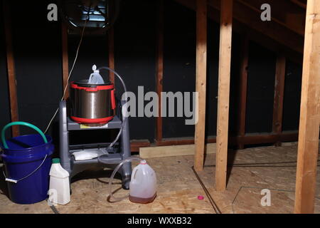 Meth Lab hergestellt aus Kunststoff Flaschen, Schläuche, und ein schnellkochtopf in einer Mansarde mit einem Ventilator für Belüftung Stockfoto