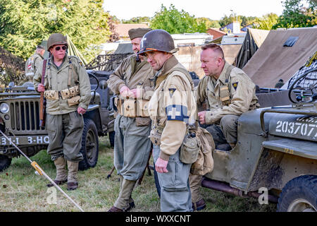 Gruppe von Männern als 1940 US-Soldaten im Vintage Uniformen neben uns militärische Fahrzeuge bei der jährlichen 40er Wochenende im Holt Norfolk gekleidet Stockfoto