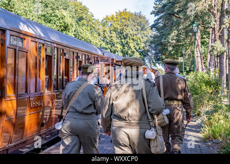 Gruppe von Menschen als 1940 Soldaten bis zu Fuß den Bahnsteig im Holt eine Schiene an Bord während der jährlichen 40er Wochenende in H gekleidet Stockfoto