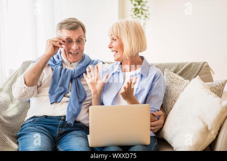 Überrascht senior Paar gewinnen online Auktion bieten auf Laptop Stockfoto
