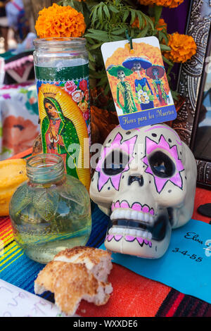 Ein Altar mit bunten Zucker Schädel/Calaveras, Kerzen, und Obst an der Dia de Los Muertos/Tag der Toten Festival in Mesilla, New York, Stockfoto