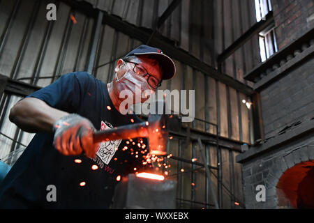 Kinmen, China. 18 Sep, 2019. Ein Handwerker schmieden Kinmen stahl Messer auf einem Workshop im Südosten Chinas Kinmen auf Sept. 18, 2019. Der Stahl Messer mit Rohstoffen von weggeworfenen Schalen geschmiedet ist eine berühmte Produkt der Kinmen. Credit: Chen Bin/Xinhua/Alamy leben Nachrichten Stockfoto