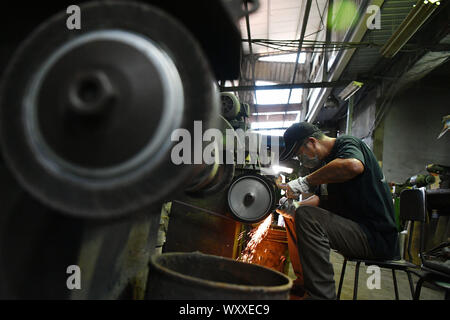 Kinmen, China. 18 Sep, 2019. Ein Handwerker schmieden Kinmen stahl Messer auf einem Workshop im Südosten Chinas Kinmen auf Sept. 18, 2019. Der Stahl Messer mit Rohstoffen von weggeworfenen Schalen geschmiedet ist eine berühmte Produkt der Kinmen. Credit: Chen Bin/Xinhua/Alamy leben Nachrichten Stockfoto