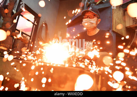 Kinmen, China. 18 Sep, 2019. Ein Handwerker schmieden Kinmen stahl Messer auf einem Workshop im Südosten Chinas Kinmen auf Sept. 18, 2019. Der Stahl Messer mit Rohstoffen von weggeworfenen Schalen geschmiedet ist eine berühmte Produkt der Kinmen. Credit: Chen Bin/Xinhua/Alamy leben Nachrichten Stockfoto